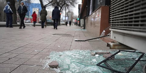 People walk past a shop with windows broken during clashes in Almaty. (Photo| AP)
