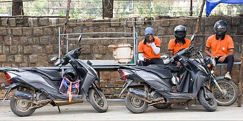 Delivery personnel await orders on a deserted road in Tiruchy on Sunday. (Photo | MK Ashok Kumar)