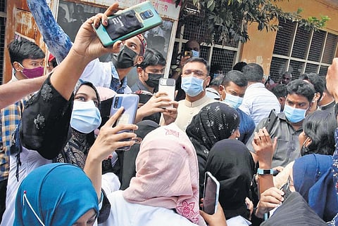 AIMIM MLA Akbaruddin Owaisi poses as medical students ask him for a selfie at the launch of ‘precautionary’ doses in the State on Monday, Jan 11, 2022. (Photo | EPS, RVK Rao)