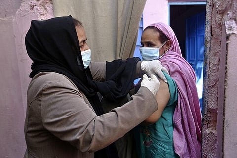 A woman receives a COVID-19 vaccine from a health worker during a door-to-door campaign to help protect people from the coronavirus, in Karachi. (Photo | AP)