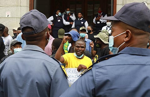 Police keep an eye on supporters of Zandile Mafe protesting outside the Magistrates Court in Cape Town, South Africa, Tuesday, Jan. 11, 2022. (Photo | AP)