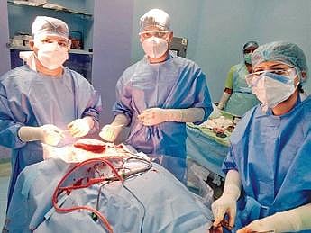 Doctors performing surgery to remove the baby's bony tail