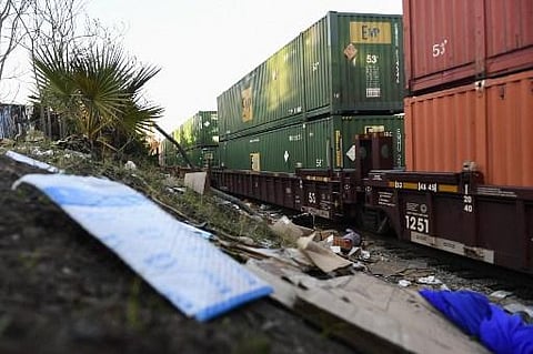 A train passes through a section of Union Pacific train tracks littered with thousands of opened boxes and packages stolen from cargo shipping containers. (Photo | AFP)