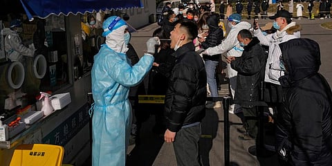 People line up to get a swab for the COVID-19 test to meet traveling requirements at a mobile coronavirus testing facility outside a commercial office buildings in Beijing.(Photo | AP)