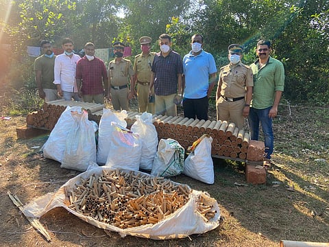 Kasaragod police pose with the explosives seized from a godown of a cracker shop in Kumbla near Kasaragod on Sunday.