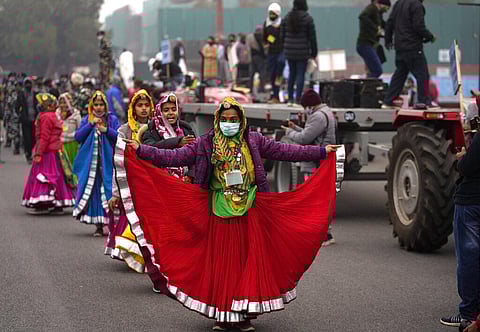 An artist wearing mask as a precaution against the coronavirus dances with others not wearing masks as they rehearse for the upcoming Republic Day parade, in New Delhi. (Photo | AP)