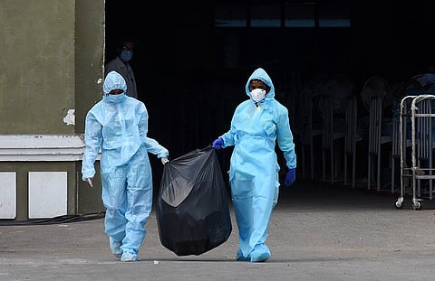 Health workers in PPE suit carry medical waste for disposal at a Covid Care Centre in Chennai. (Photo | Ashwin Prasath, EPS)