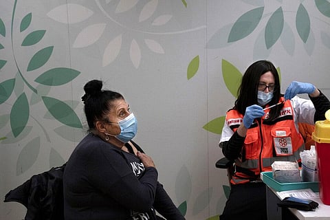 Esther Pamensky, a volunteer with the women's unit of United Hatzalah emergency service, prepares a fourth dose of the COVID-19 vaccine. (File Photo | AP)