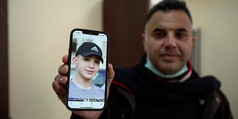 FILE - Muamar Nakhleh, father of Amal Nakhleh, who has been held without charge for a year by Isreali authorities shows his photo at his office, Ramallah, Jan, 10, 2022. (Photo | AP)