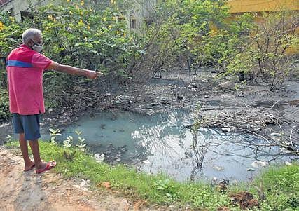 A resident of Subam Nagar points at the water mixed with sewage in his locality. (Photo| Ashwin Prasath, EPS)