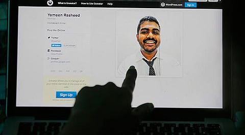 A Sri Lankan woman in Colombo points to a photo of murdered Maldivian blogger Yameen Rasheed from his blog, April 23, 2017. (File Photo |AP/Eranga Jayawardena)