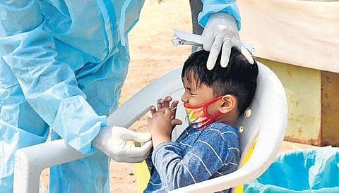 A boy keeps his eyes tightly closed while being tested for Covid-19 at Fever Hospital, in Hyderabad, on Wednesday | R V K Rao