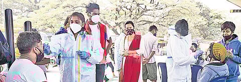 Healthcare workers collect swab samples of people at KR Market amid rising cases in Bengaluru. (Photo| Vinod Kumar T, EPS)