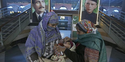 A health worker administers a polio vaccine to a child at a railway station in Lahore, Pakistan, Monday, Jan. 24, 2022. (Photo | AP)