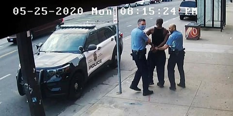 Minneapolis police Officers Thomas Lane (L) and J. Alexander Kueng (R) escorting George Floyd (C) to a police vehicle outside Cup Foods in Minneapolis. (Photo | AP)