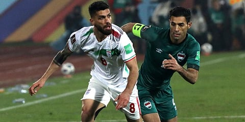Iraq's Saad Abdulameer (R) follows Iran's Milad Sarlak during their 2022 World Cup qualifier soccer match, at the Azadi stadium in Tehran, Iran. (Photo | AP)