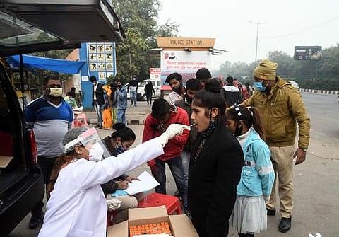 A Health worker takes swab sample for Covid19 test at akshardham metro station in New Delhi. (Photo | EPS file)