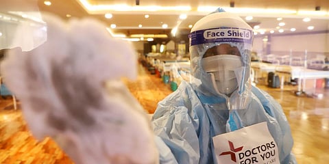 A healthcare worker sanitise a temporarily converted isolation ward for COVID-19 patients at Shehnai Banquet Hall, in New Delhi. (Photo| ANI)
