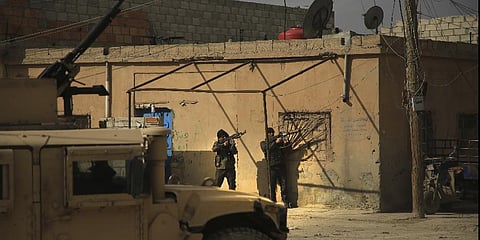 Kurdish-led Syrian Democratic Forces fighters, take their positions at an alley near Gweiran Prison, in Hassakeh, northeast Syria, Sunday, Jan. 23, 2022. (Photo | AP)