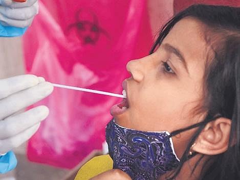 A health worker takes a swab sample of a woman in Bengaluru on Sunday| Ashishkrishna H P