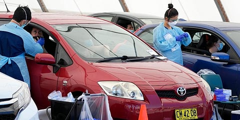 Medical staff collect COVID-19 swabs from people at a drive-though clinic in Sydney. (Photo | AP)