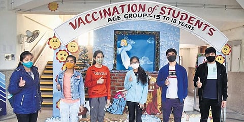 Students flash the victory sign after receiving a dose of COVID-19 vaccine in New Delhi on Monday. (Photo | Parveen Negi, EPS)