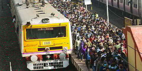Passengers board and deboard at a railway station flouting COVID-19 social distancing norms in Kolkata. (Photo| ANI)