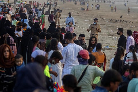 An Indian policeman asks people to leave the Juhu beach amid restrictions imposed due to rising numbers of COVID-19 cases. (Photo | AP)