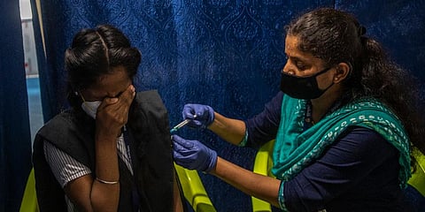 A schoolgirl reacts as she receives vaccination for COVID-19 at a vaccination center in Mumbai. (Photo | AP)