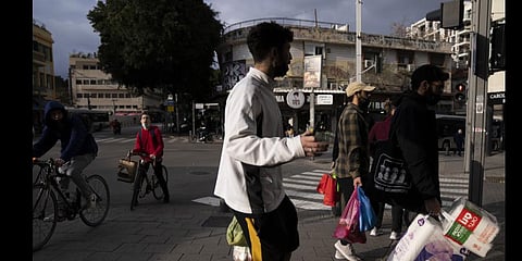 People, some wear protective face masks on their chin shop in Tel Aviv, Israel (Photo | AP)