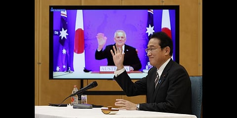 Japan's Prime Minister Fumio Kishida, right, and Australia's Prime Minister Scott Morrison seen on screen, attend a virtual summit to sign the Reciprocal Access Agreement. (Photo | AP)