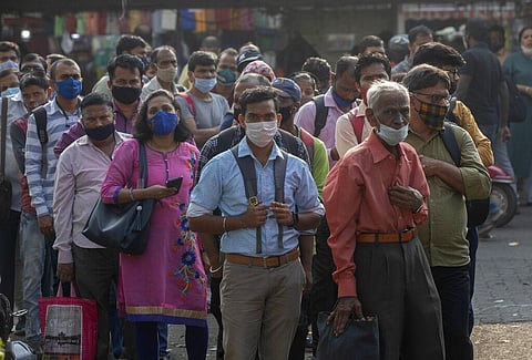 People wearing face masks as a precaution against the coronavirus wait for bus in Mumbai, India, Tuesday, Jan. 4, 2022. (Photo | AP)