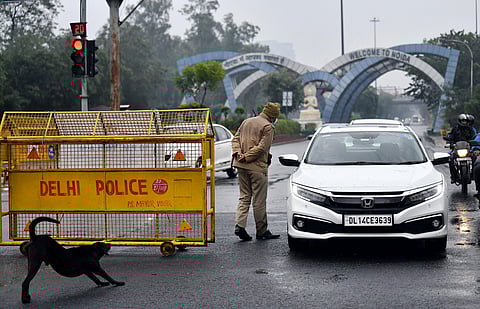 Delhi Police personnel checking a vehicle during the weekend curfew, in Delhi on Saturday. (Photo|ANI)