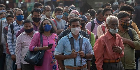 People wearing face masks as a precaution against the coronavirus wait for bus in Mumbai. (Photo | AP)