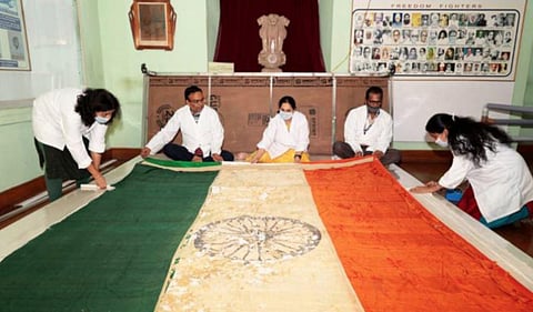 Experts working on the national flag which was hoisted at Chennai's Fort St George on August 15, 1947
