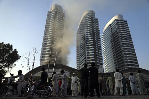 People watch as smoke rises from the Centaurus Mall after a gas cylinder exploded in a food court causing a fire in the tallest building complex in Islamabad, Pakistan, Sunday, Oct. 9, 2022. (Photo |