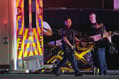 A law enforcement officer walks past an EMS crew on the scene at Kennywood Park, an amusement park in West Mifflin, Pa., early Sunday, Sept 25, 2022. (Photo | AP)