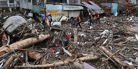 Rescue teams and family members search through the rubble of houses swept away by the flooding of a creek, in Las Tejerías, Aragua state, Venezuela, on October 9, 2022.(Photo | AFP)