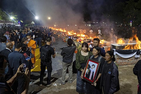 Victim's relative pose in front of funeral pyres set to cremate those who died in the day care center attack at Wat Rat Samakee temple in Uthai Sawan, northeastern Thailand. (Photo | AP)