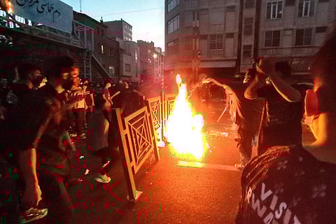 Protesters make fire and block the street during a protest over the death of a woman who was detained by the morality police, in downtown Tehran. (File Photo | AP)