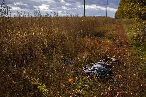 The body of a local man who was killed after an explosion of a Russian mine lies on the ground near Hrakove village, Ukraine. (Photo | AP)