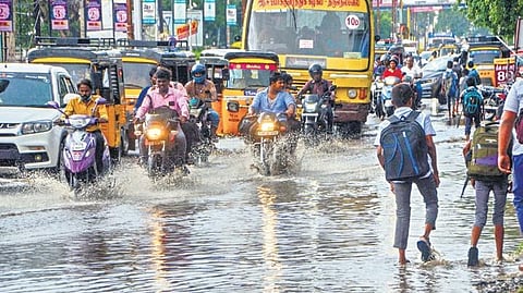 Vehicles negotiate waterlogged road at Vannarpettai in Tirunelveli on Friday after heavy rains lashed most parts of Tamil Nadu 