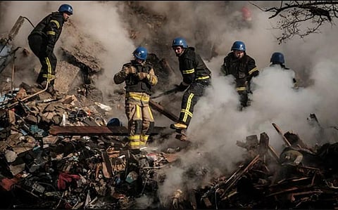 Ukrainian firefighters works on a destroyed building after a drone attack in Kyiv on October 17, 2022. (Photo | AFP)