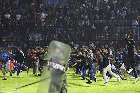 Soccer fans enter the pitch during a clash between supporters at Kanjuruhan Stadium in Malang, East Java, Indonesia, Saturday, Oct. 1, 2022. (Photo | AP)