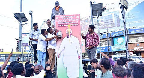 Followers of Mallikarjun Kharge perform Kshirabhisheka on his portrait in Kalaburagi. (Photo | Express)