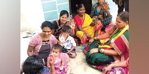 Women display lotus symbol on their palms in a village in Munugode on Wednesday