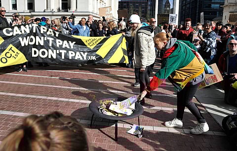 Protesters seen burning symbolic energy bills outside the ICC in Birmingham prior to the Conservative Party conference in this October 1, 2022 photo. (Associated Press)