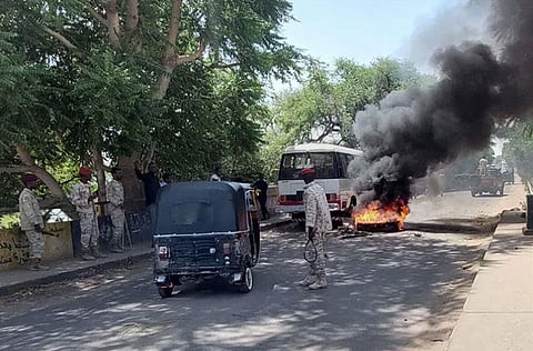 Sudanese security forces intervene as smoke billows from a burned tyre near a bridge that separates the two parts of the city of Nyala, the capital of South Darfur. (Photo | AFP)