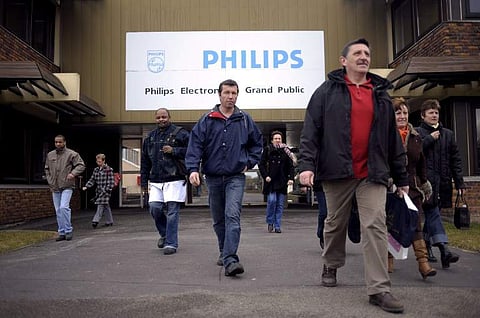 In this backdated photograph, workers of Dutch electronics giant Philips' factory of Dreux, central France, seen leaving their morning shift. (File Photo | AFP)
