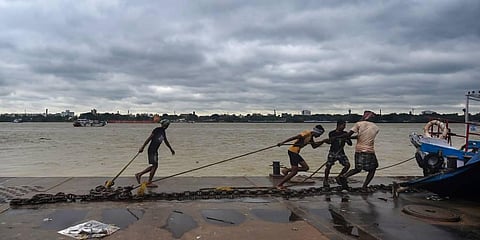 Workers anchor a ferry on the bank of the Ganga river, as a precautionary measure ahead of the landfall of cyclone Sitrang. (Photo | PTI)